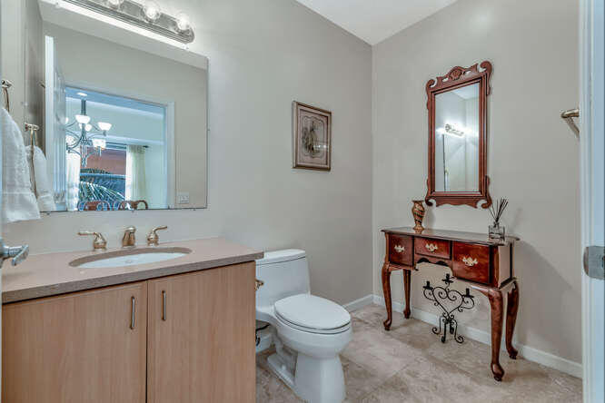 1640 Presidential Way, Unit 501 West Palm Beach, FL 33401 - Photo 21 of 36 a bathroom with a toilet a sink and mirror