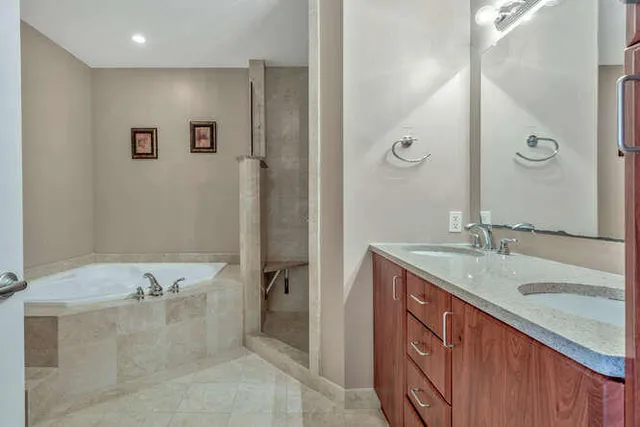 a bathroom with a granite countertop sink mirror and a bathtub