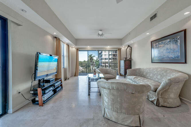 1640 Presidential Way, Unit 501 West Palm Beach, FL 33401 - Photo 27 of 36 a living room with furniture and a flat screen tv