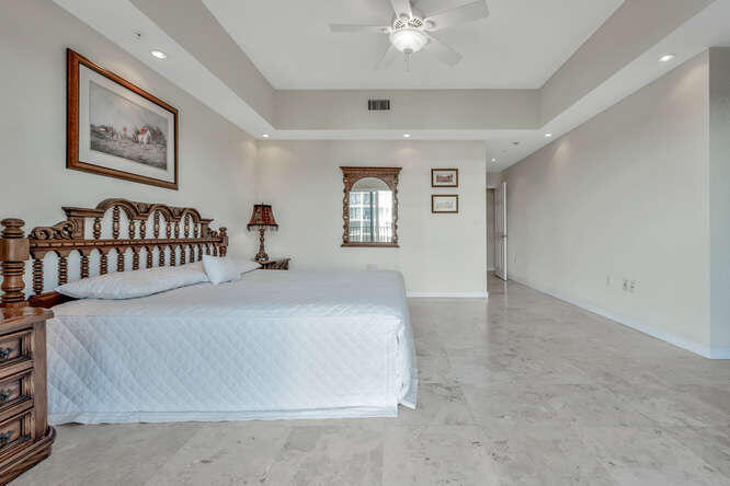 1640 Presidential Way, Unit 501 West Palm Beach, FL 33401 - Photo 29 of 36 a bedroom with a bed and a chandelier
