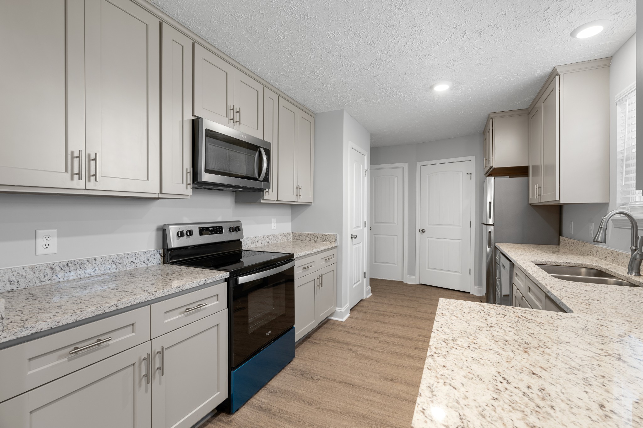 a kitchen with granite countertop cabinets stainless steel appliances and a sink