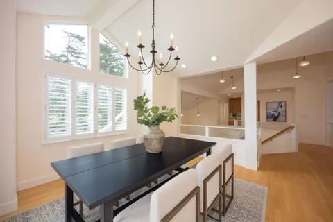 a kitchen with granite countertop a table chairs and wooden floor