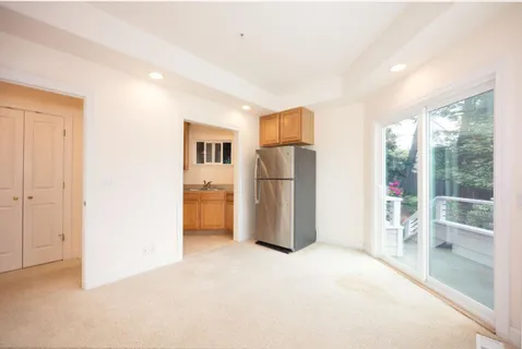 a view of empty room with a kitchen