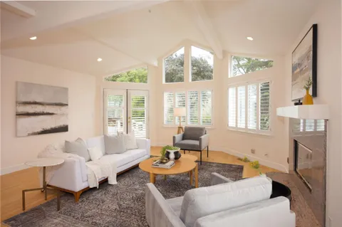 a living room with fireplace furniture and a large window