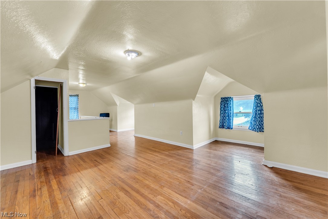 5619 Dunham Road Maple Heights, OH 44137 - Photo 15 of 19 Bonus room with a textured ceiling, hardwood floors, and vaulted ceiling
