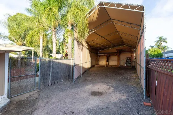 a view of a house with a door and wooden fence