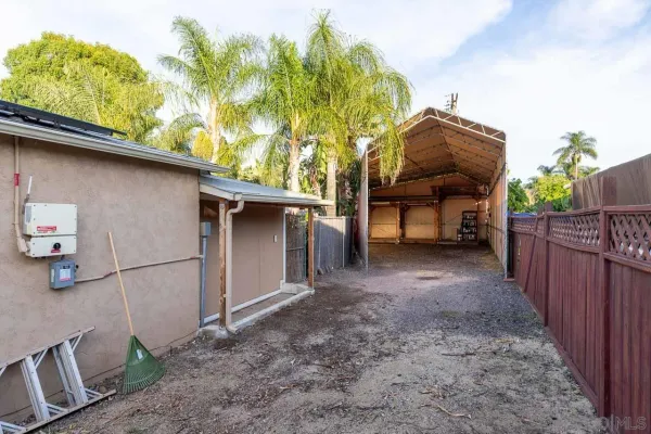 a view of backyard and wooden fence