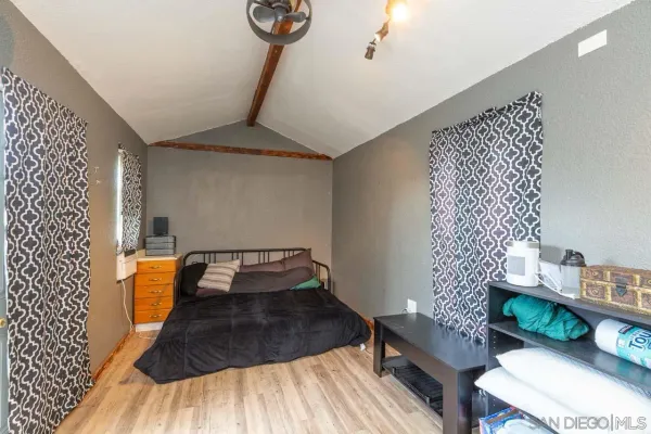 a bedroom with a bed and a wooden floor