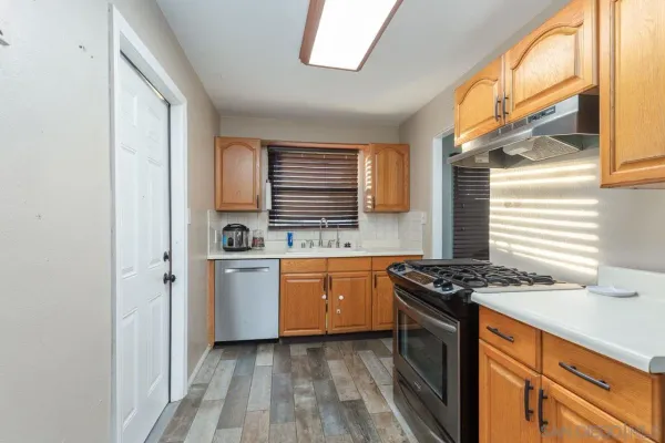 a kitchen with stainless steel appliances granite countertop a stove a sink and a refrigerator