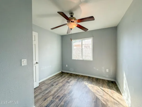 a view of room with window ceiling fan and wooden floor