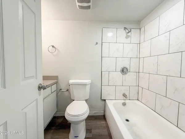 a white toilet sitting next to a bath tub and shower