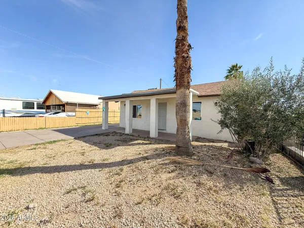 a row of palm trees in front of a house
