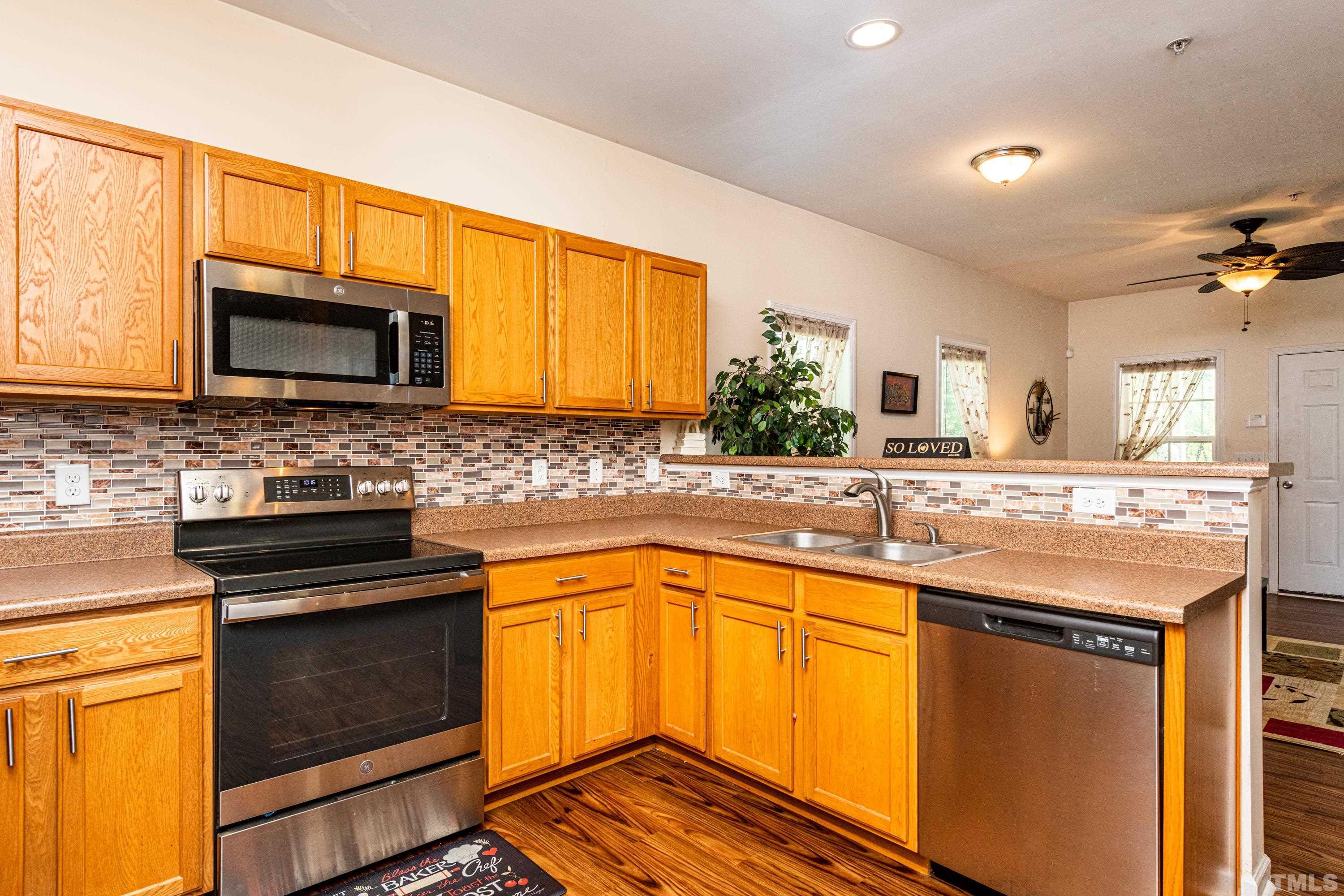 1208 Wall Street Durham, NC 27701 - Photo 13 of 27 a kitchen with stainless steel appliances granite countertop wooden cabinets stove and microwave
