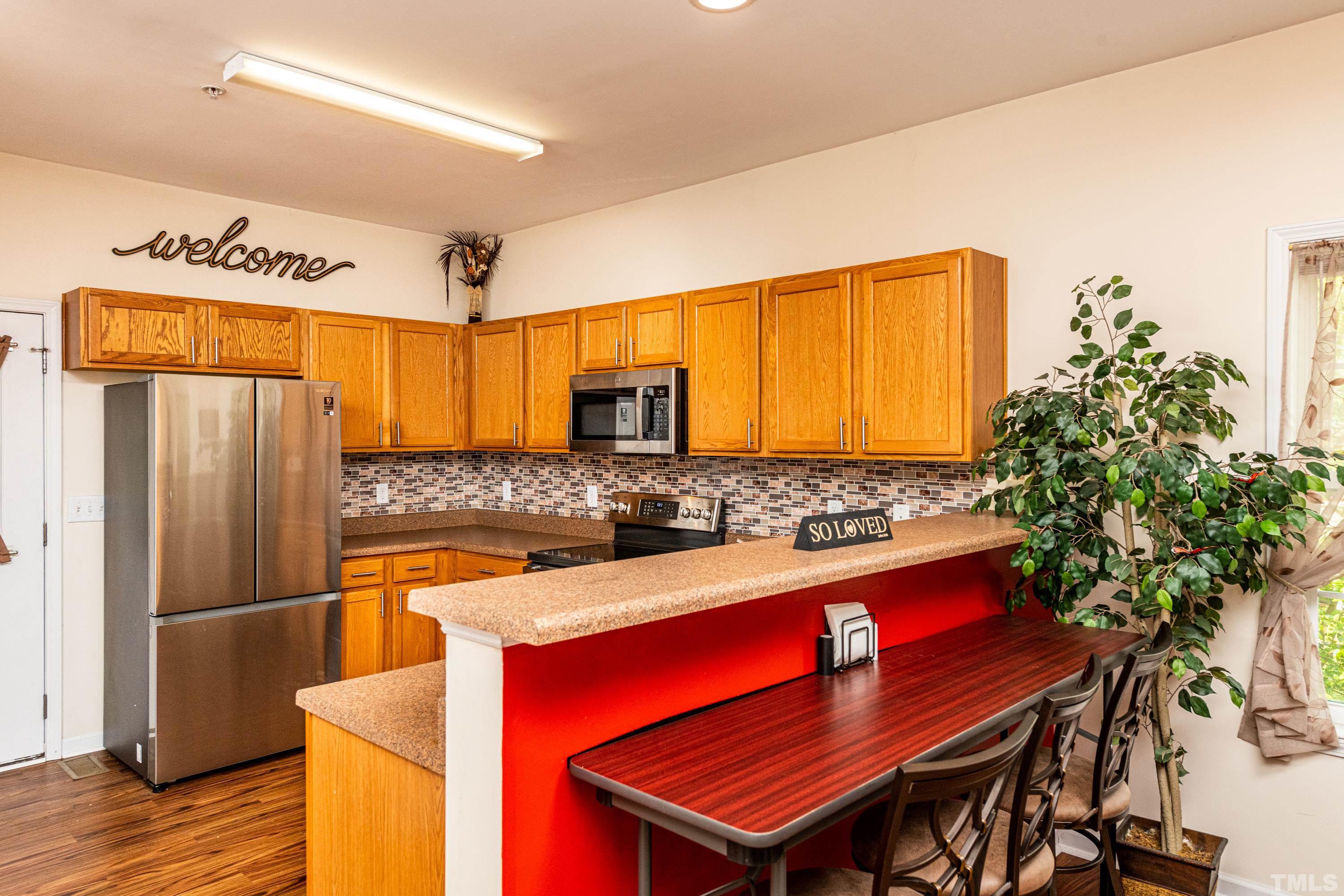 1208 Wall Street Durham, NC 27701 - Photo 10 of 27 a kitchen with stainless steel appliances kitchen island granite countertop a table chairs in it and wooden floor
