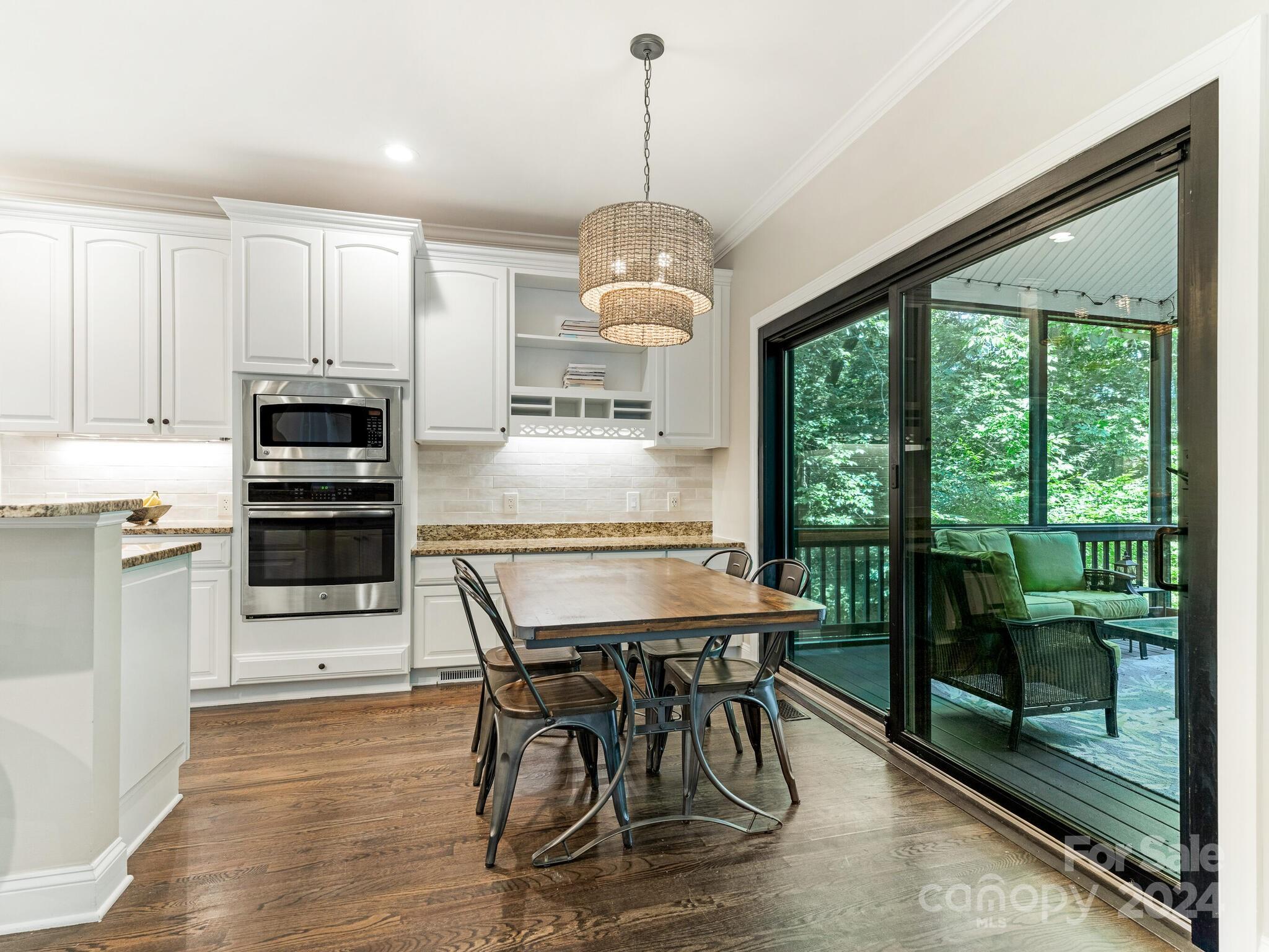 3234 Planters Ridge Road Charlotte, NC 28270 - Photo 9 of 33 a kitchen with stainless steel appliances granite countertop a stove top oven a sink with a dining table and chairs