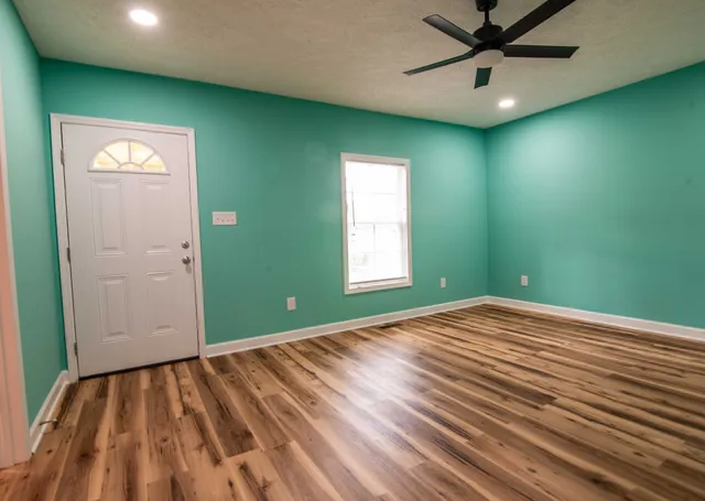 an empty room with window and a ceiling fan