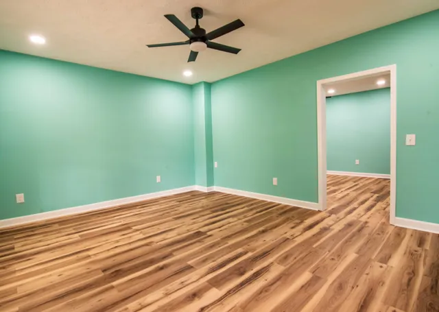 a view of a big room with wooden floor and a ceiling fan