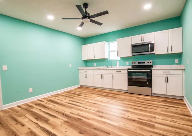 a kitchen with stainless steel appliances granite countertop a cabinets and a wooden floor