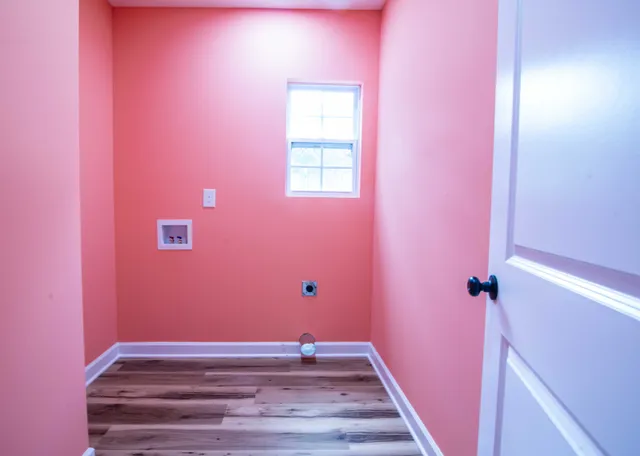 a view of a room with wooden floor and small window