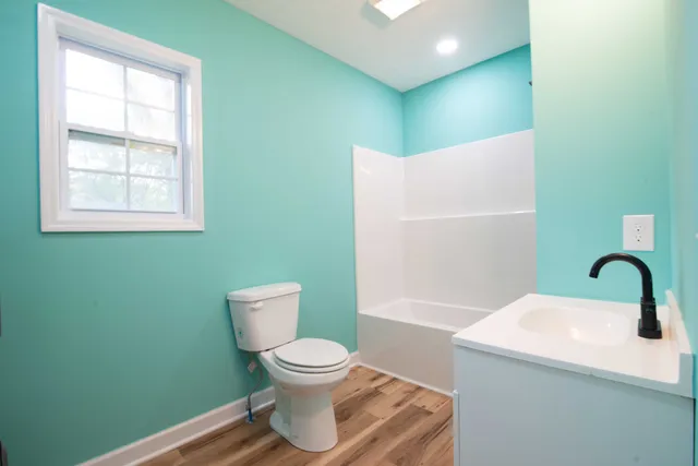a bathroom with a toilet sink and mirror