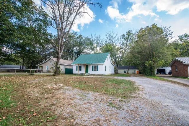 a front view of a house with a yard and trees