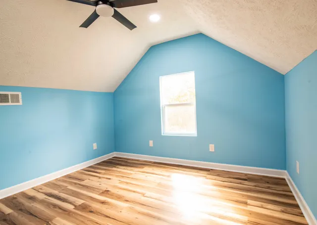 a view of a room with a ceiling fan and a window