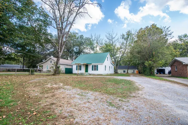 a front view of a house with a yard and trees
