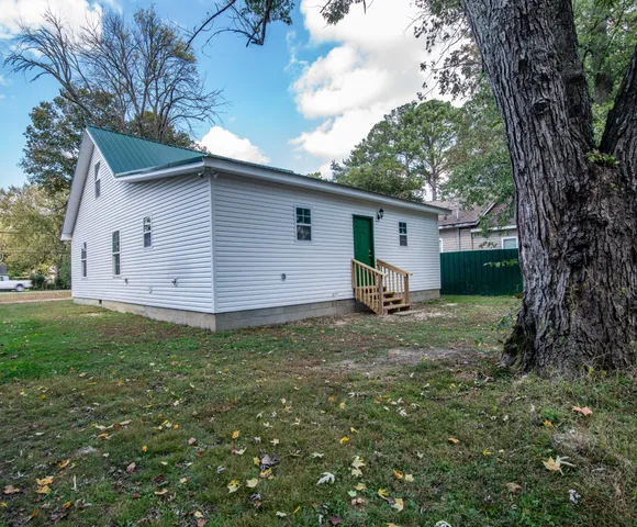 a backyard of a house with table and chairs