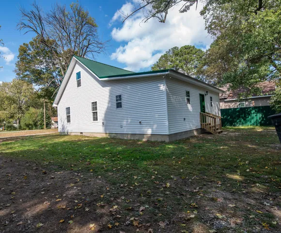 a view of backyard of house with green space