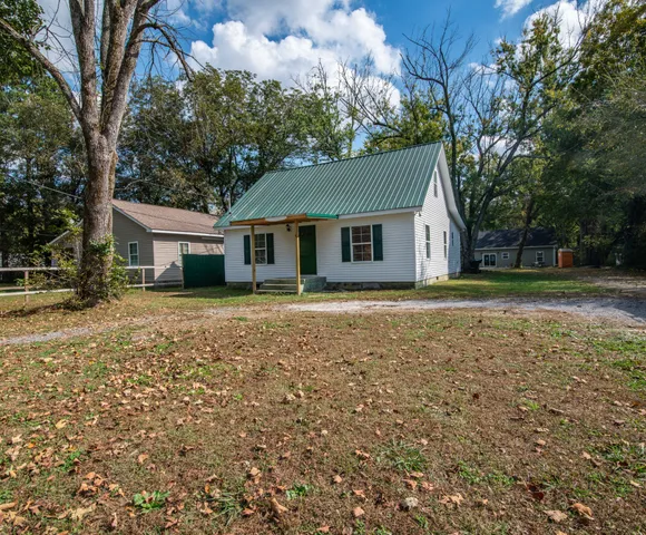 a front view of house with yard and trees around