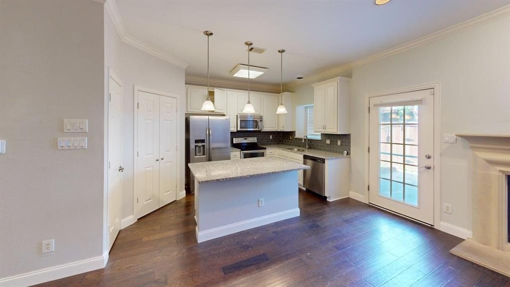 18240 Midway Road, Unit 1204 Dallas, TX 75287 - Photo 19 of 27 a large kitchen with cabinets wooden floor and stainless steel appliances