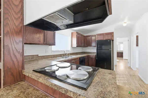 a kitchen with stainless steel appliances granite countertop a sink a stove and a refrigerator