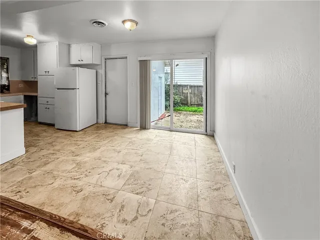 a view of a kitchen with refrigerator and windows
