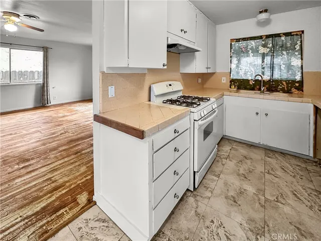a kitchen with granite countertop a sink and a stove