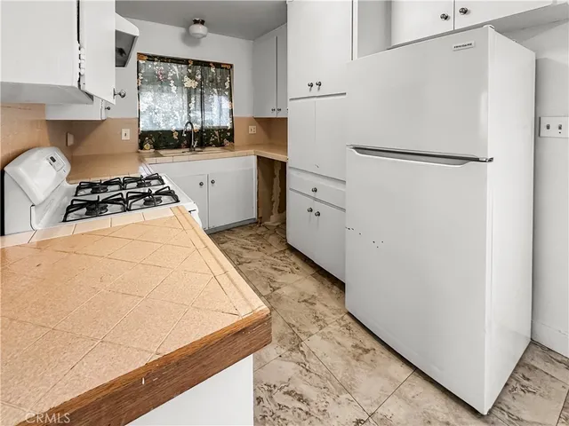 a kitchen with white cabinets and white appliances