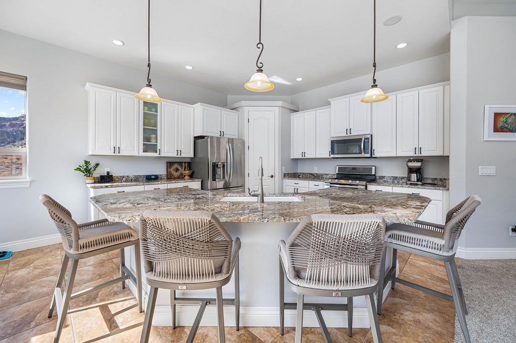 2283 Trail Ridge Road Grand Junction, CO 81507 - Photo 13 of 35 a kitchen with stainless steel appliances granite countertop a stove a refrigerator a kitchen island a table and chairs
