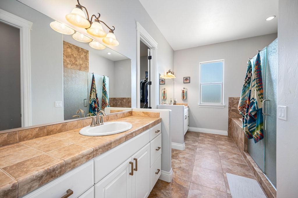 2283 Trail Ridge Road Grand Junction, CO 81507 - Photo 20 of 35 a bathroom with a granite countertop sink a toilet and a mirror