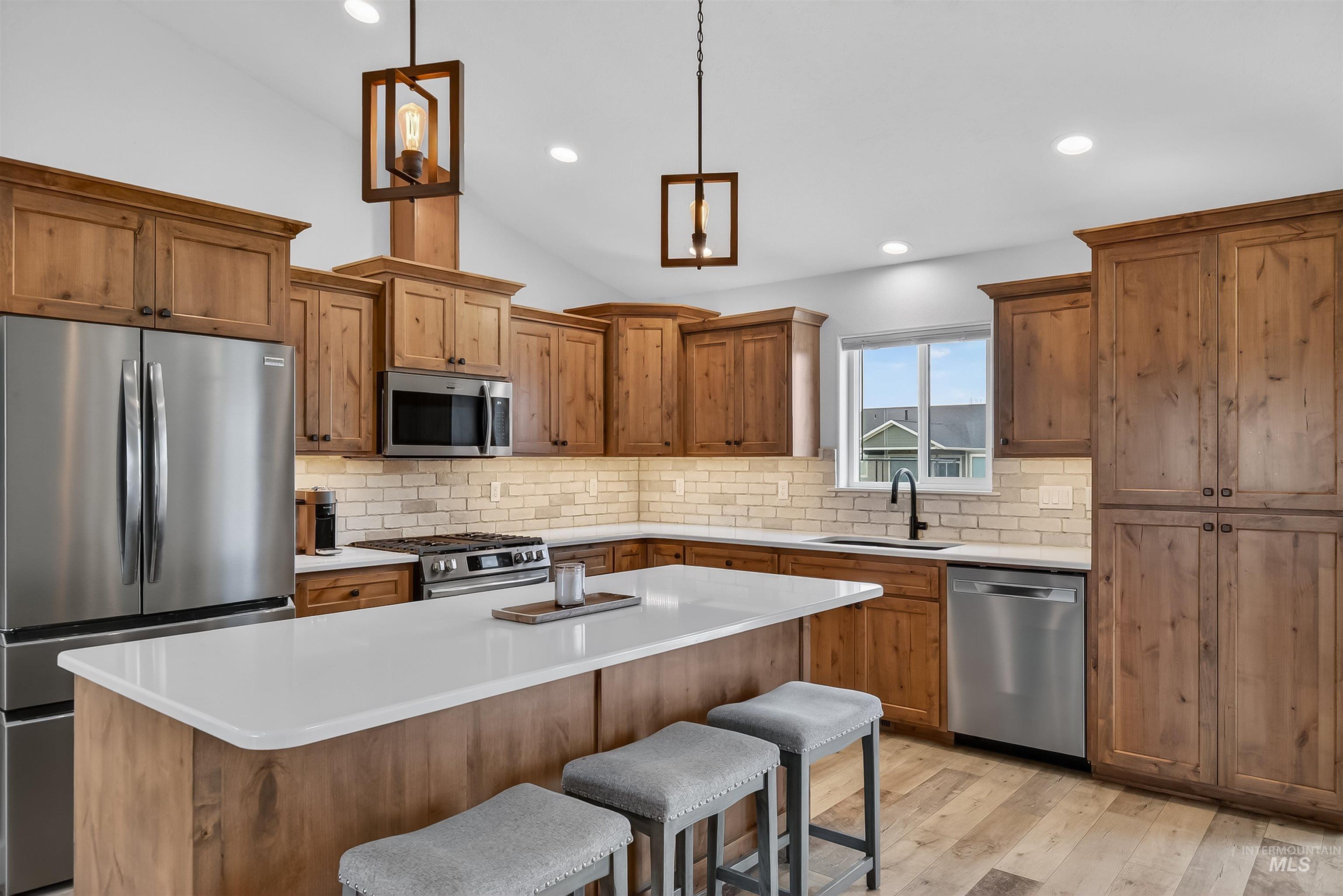 3732 Skyview Drive Lewiston, ID 83501 - Photo 11 of 47 Kitchen featuring stainless steel appliances, wood finish cabinetry, a breakfast bar area, light wood-type flooring, and a kitchen island