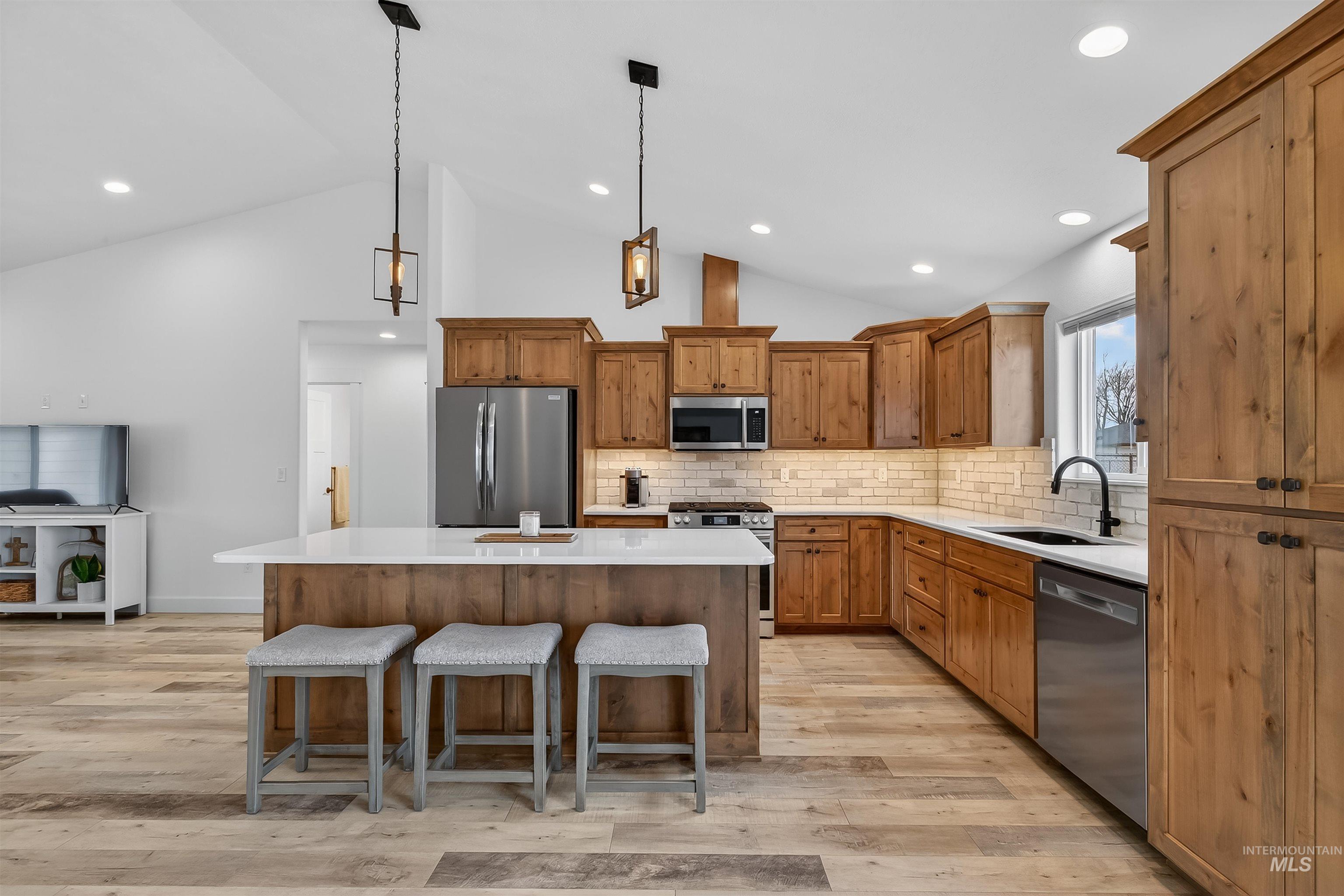 3732 Skyview Drive Lewiston, ID 83501 - Photo 12 of 47 Kitchen with wood finish cabinets, a center island, a breakfast bar, hanging light fixtures, and lofted ceiling