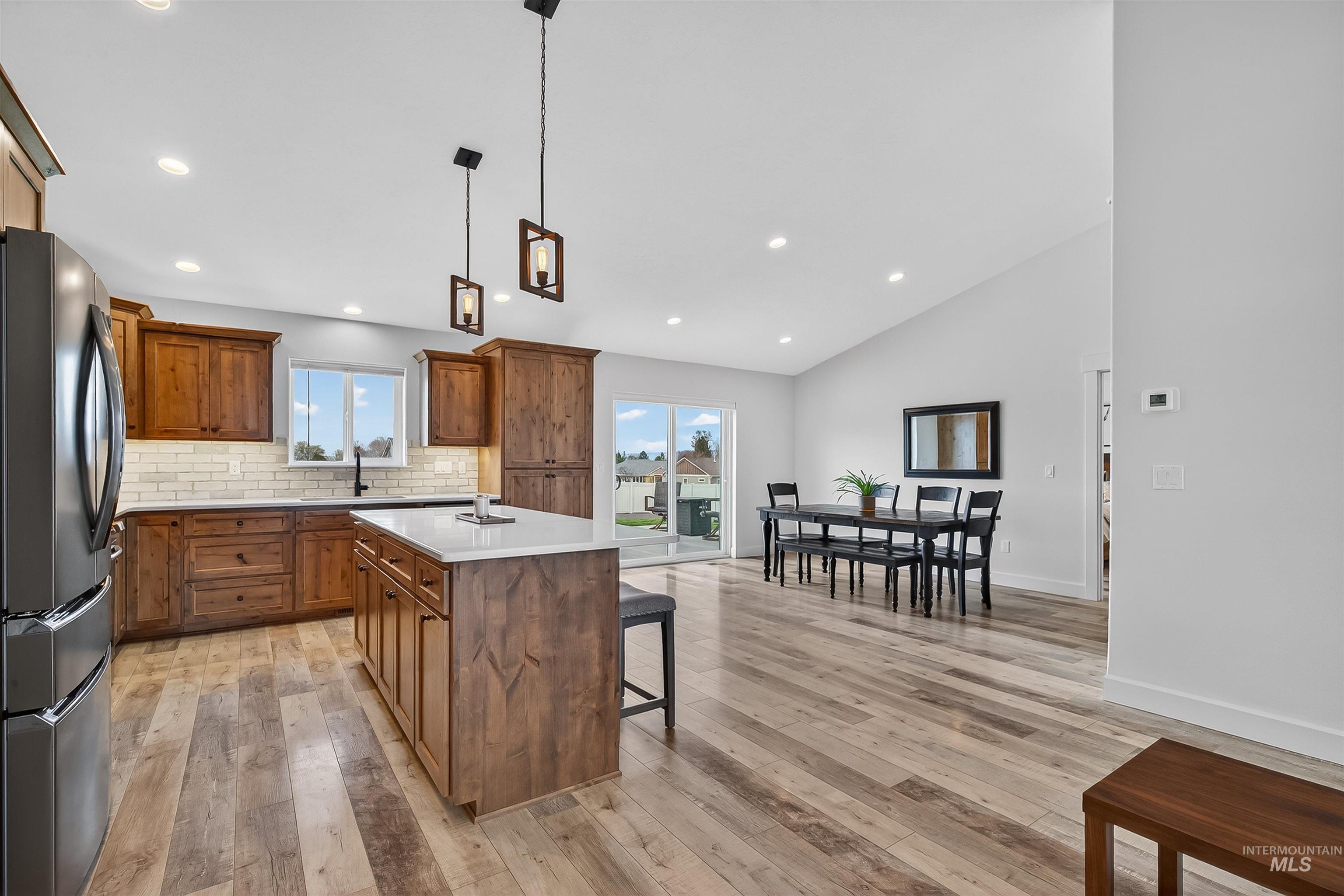 3732 Skyview Drive Lewiston, ID 83501 - Photo 13 of 47 Kitchen featuring wood finish cabinets, freestanding refrigerator, a kitchen bar, a center island, and hanging light fixtures