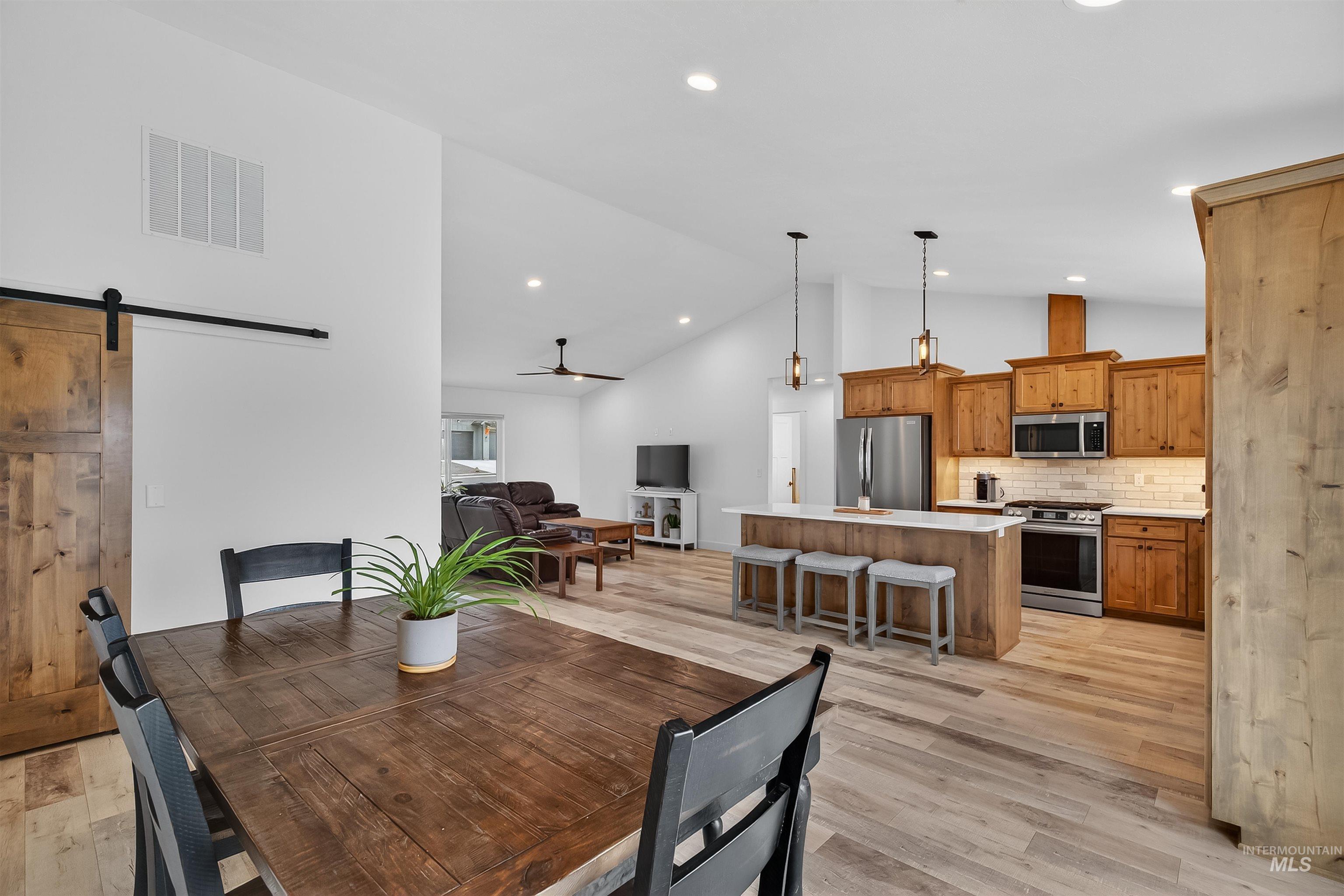 3732 Skyview Drive Lewiston, ID 83501 - Photo 16 of 47 Dining space with a barn door, lofted ceiling, light wood-style flooring, recessed lighting, and ceiling fan
