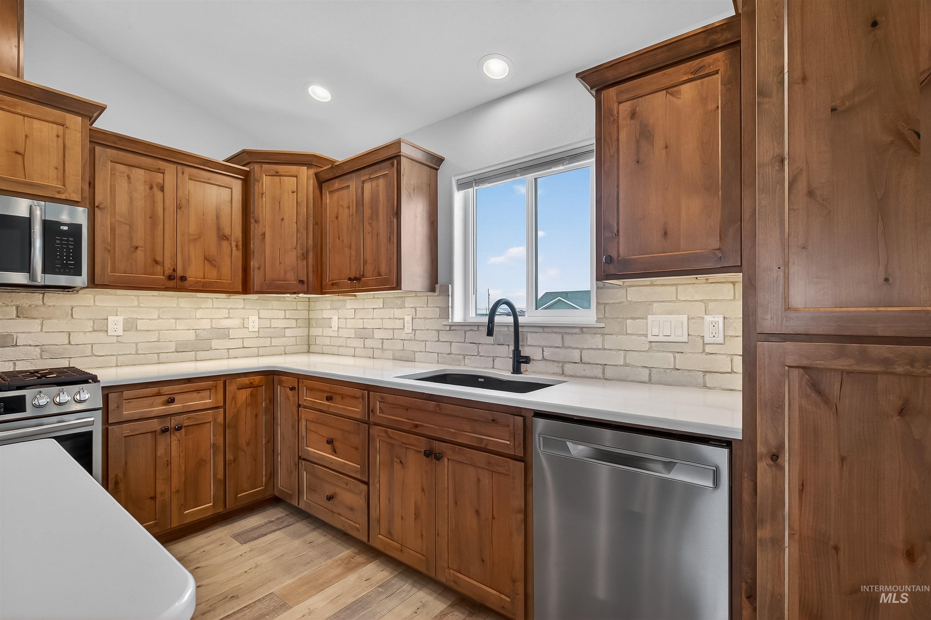 3732 Skyview Drive Lewiston, ID 83501 - Photo 9 of 47 Kitchen featuring stainless steel appliances, wood finish cabinets, light wood-type flooring, decorative backsplash, and recessed lighting