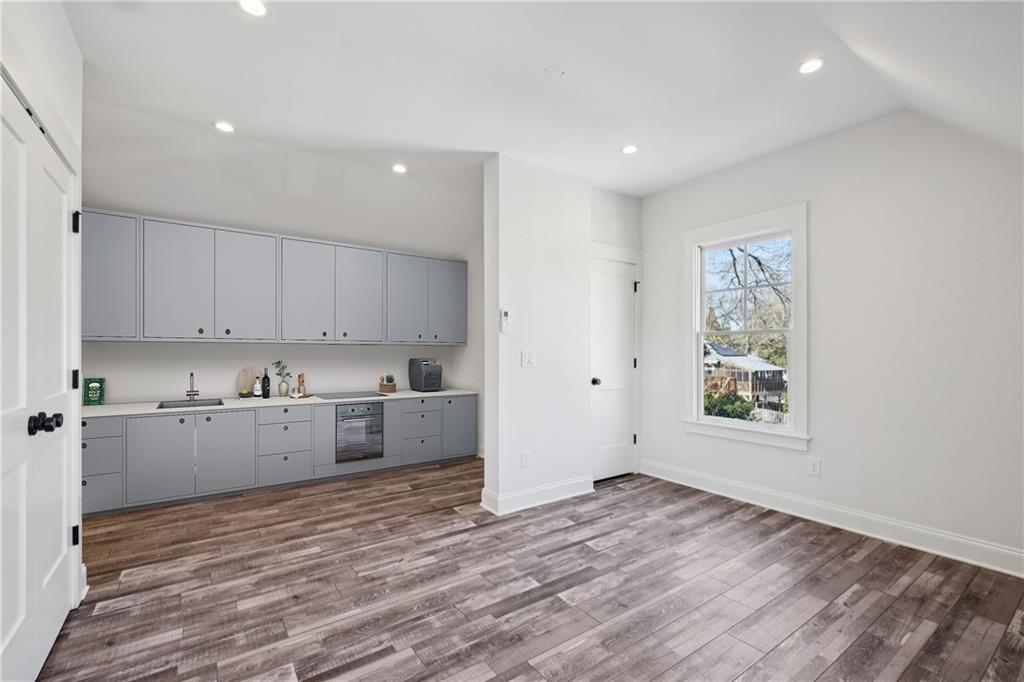 216 Haralson Lane Atlanta, GA 30307 - Photo 44 of 48 a kitchen with granite countertop a stove a sink and white cabinets with wooden floor