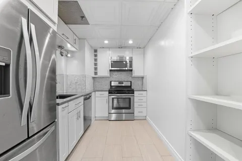 a kitchen with stainless steel appliances a refrigerator sink and stove