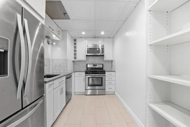 a kitchen with stainless steel appliances a refrigerator sink and stove