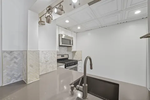 a kitchen with a sink appliances and cabinets