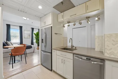 a kitchen with stainless steel appliances granite countertop a refrigerator and a sink