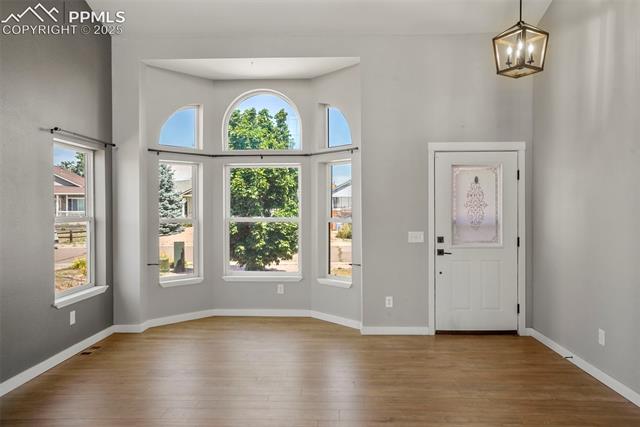 8035 Ferguson Road Peyton, CO 80831 - Photo 2 of 28 Foyer entrance featuring a chandelier, a towering ceiling, and light wood-type flooring