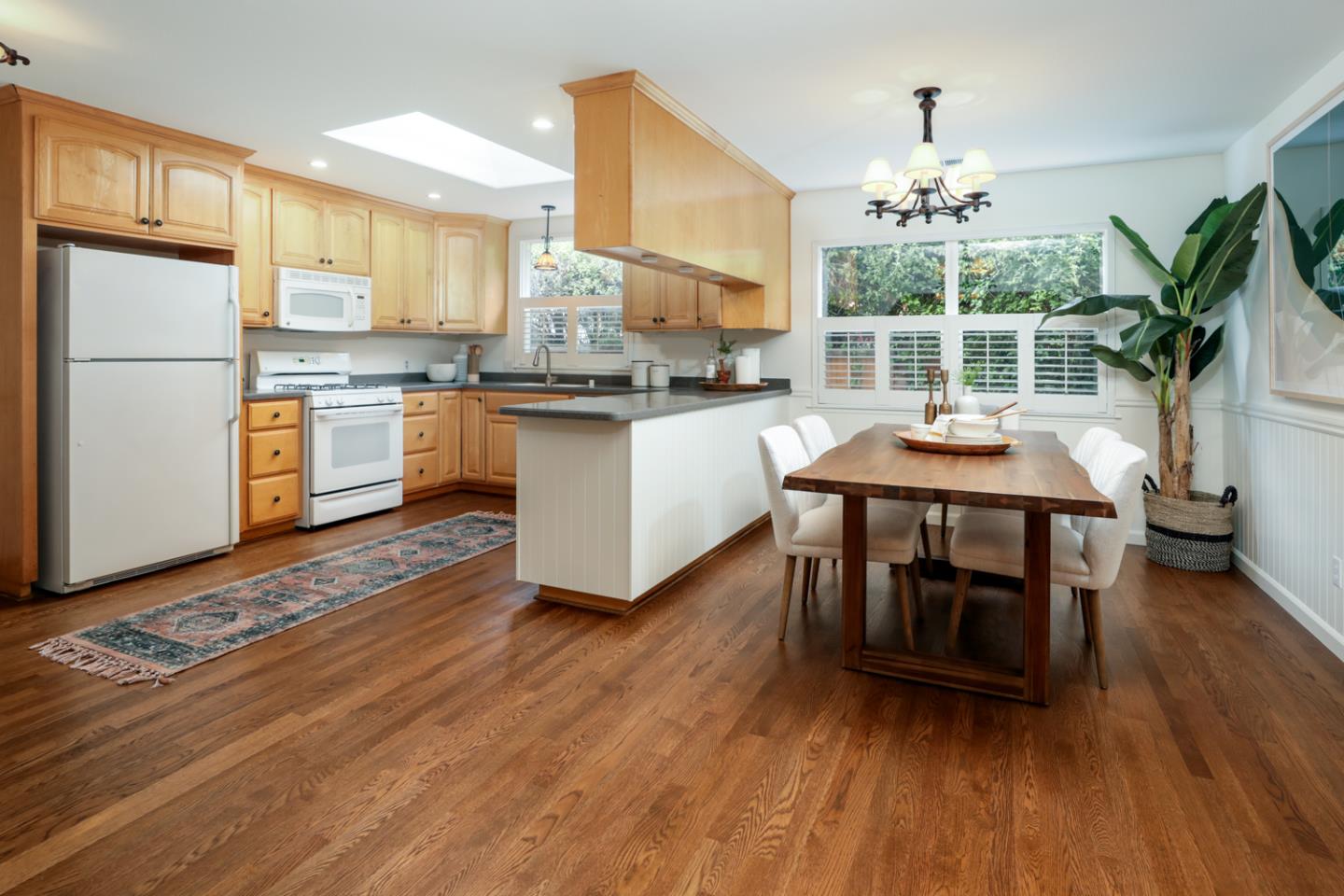 732 Laurel Avenue Menlo Park, CA 94025 - Photo 6 of 22 a kitchen with stainless steel appliances granite countertop a stove a refrigerator a microwave oven a dining table and chairs with wooden floor
