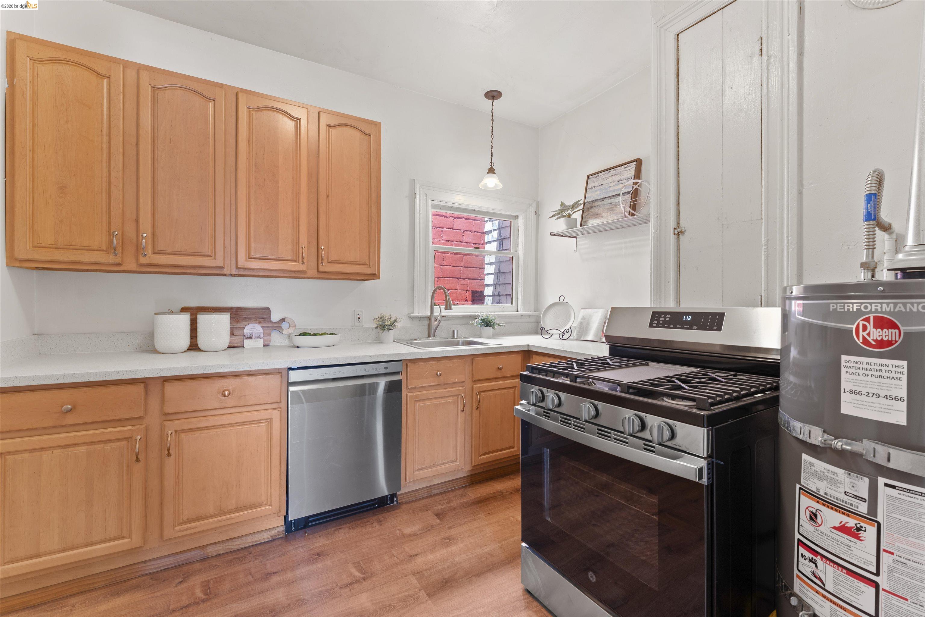667 10th Street Oakland, CA 94607 - Photo 9 of 15 a kitchen with granite countertop a stove sink and cabinets